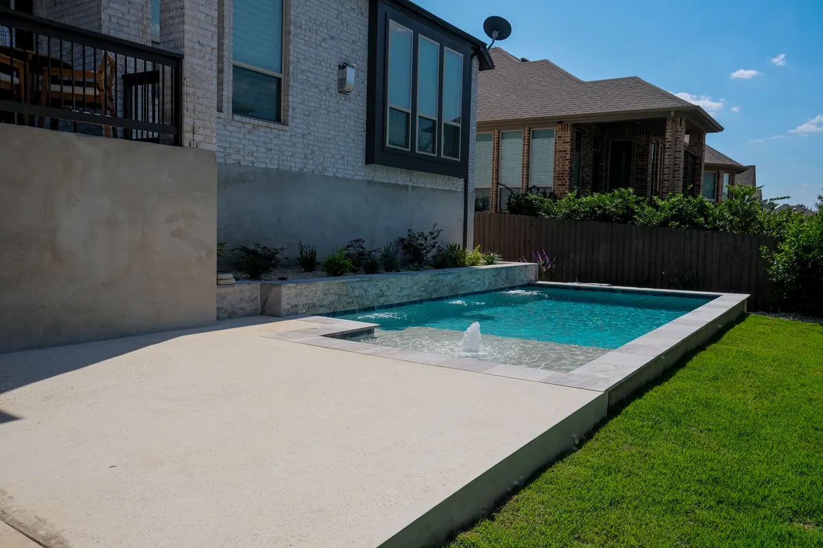 Rectangular pool and bubbler shelf beside the home