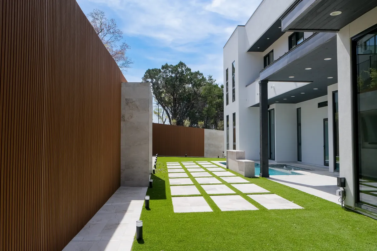 Stone stepping pads set into turf alongside the courtyard pool