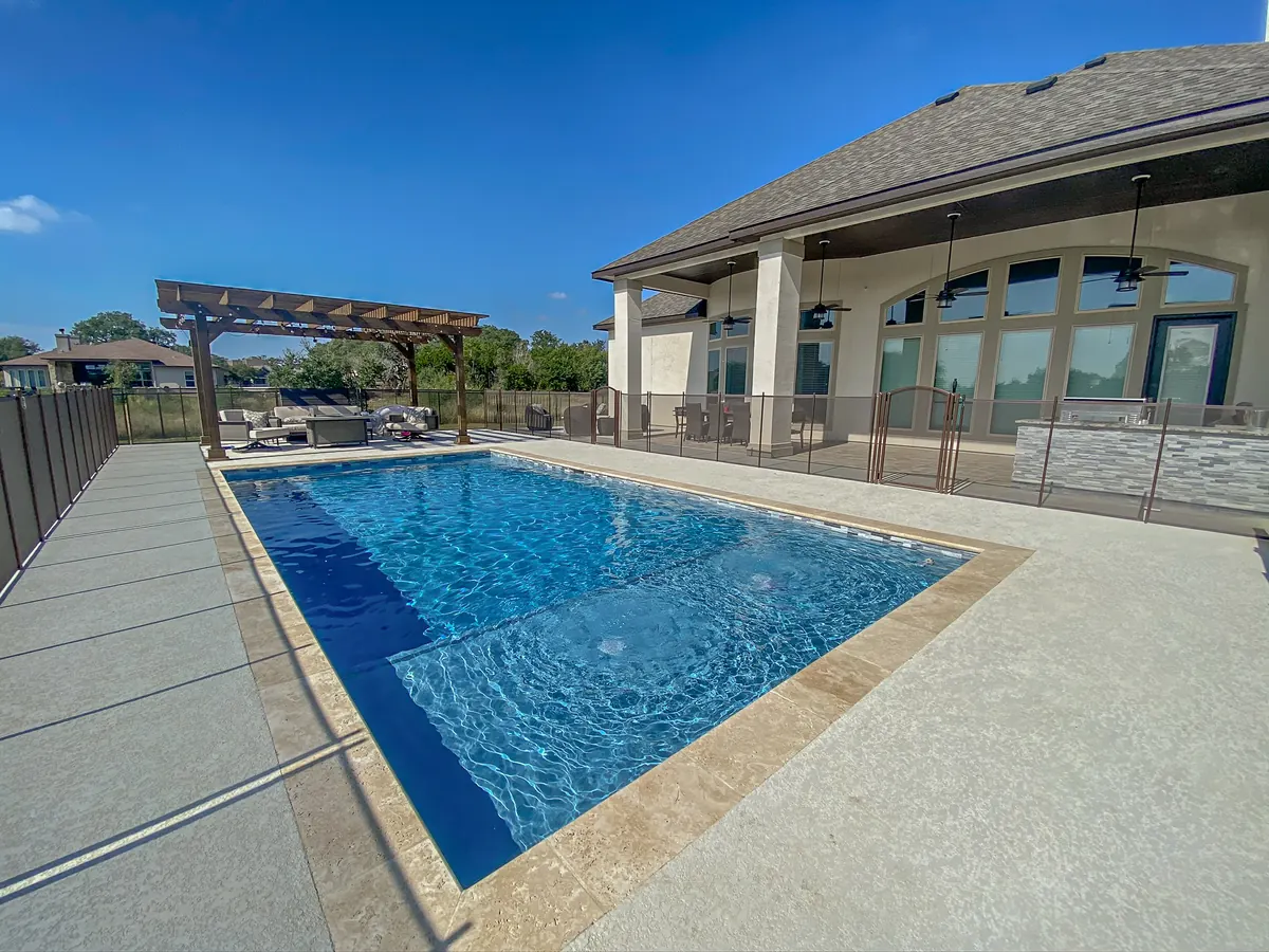 Blue pool beside a covered patio and timber pergola